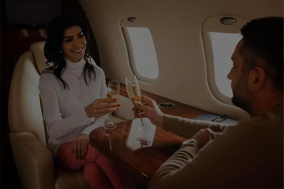 couple toasting with champagne in an airplane